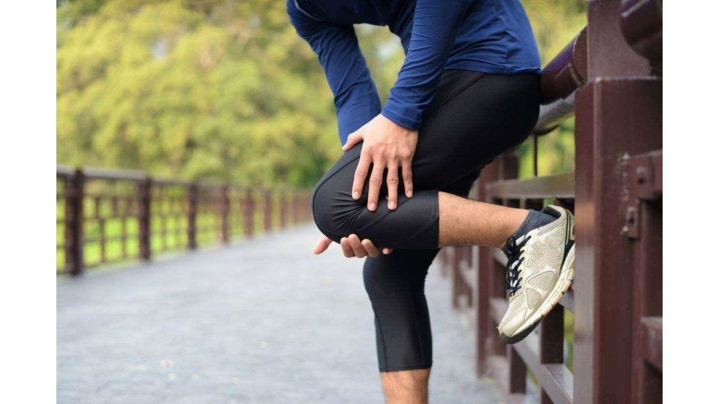 man clutching leg in pain